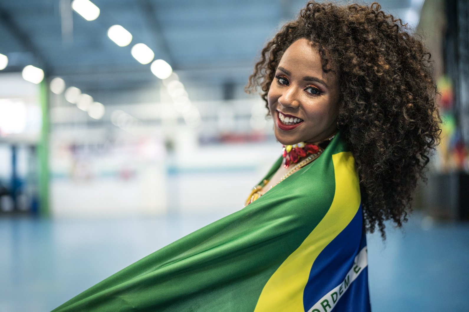 Brazilian woman wearing carnival costume holding brazilian flag